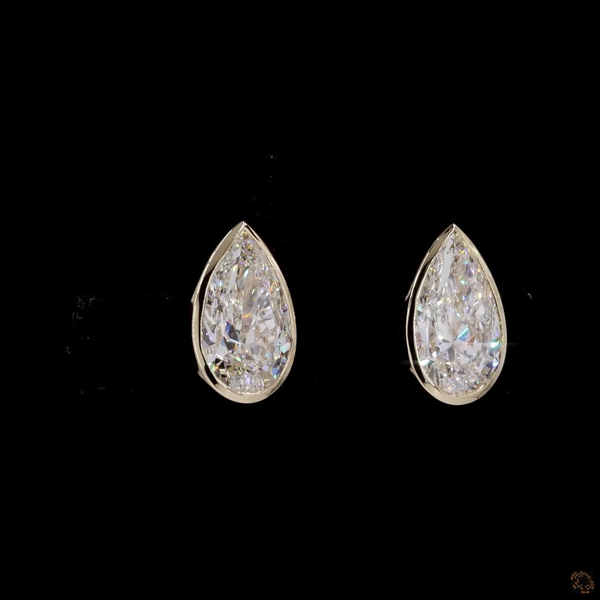 3.04 Ct Upgrade your signature collection with sleek bezel-set pear-cut solitaire diamond stud earrings in yellow gold, featuring a protective metal rim setting and comfortable push-back closures